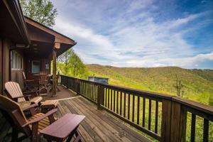 a deck with chairs and a grill on a house at A Nest With a View in Blowing Rock