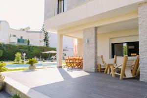 a house with a patio with a table and chairs at Villa Oliviera in Akouda