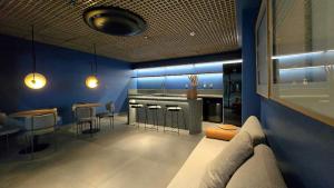 una cocina con paredes azules y un bar con taburetes en Aquamaris by Hosppedar, en Tambaú