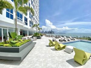 a hotel patio with chairs and a swimming pool at Seaview Comfort Studio in Panama City