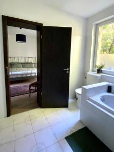 a bathroom with a door leading to a bedroom at Rózsa Vendégház INGYENES PARKOLÁSSAL in Nagykovácsi +52 photos