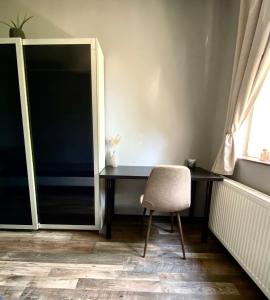 a desk in a room with a chair and a window at Rózsa Vendégház INGYENES PARKOLÁSSAL in Nagykovácsi