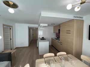 a kitchen and a living room with a table and chairs at Casa Collado Apartmento 2A in San Vicente +6 photos