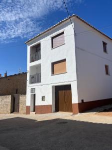a white building with a garage at Casa Collado Apartmento 2A in San Vicente