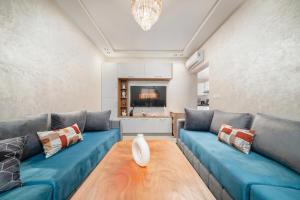 a living room with blue couches and a vase on a table at Jaws Wave ESSAOUIRA in Al Ghar