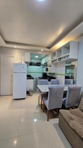 Una cocina con mesa y sillas y un refrigerador. en Condomínio Porto Esmeralda, en Ananindeua
