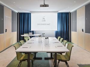 a conference room with a large white table and chairs at Novotel Rennes Alma in Rennes +106 photos