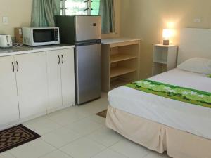 NgatangiiaにあるRei-Ris Placeの小さなキッチン(ベッド1台、冷蔵庫付)