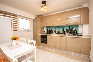 a kitchen with a white table and a white table and chairs at Apartament 21 in Craiova