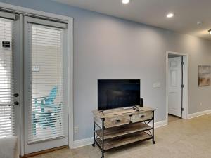 a living room with a tv and a table at The Village #514 in Blue Mountain Beach