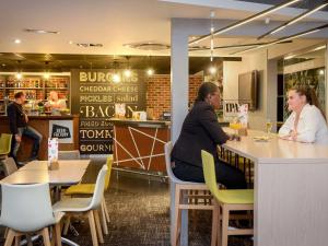 two women sitting at a counter in a restaurant at Novotel Toulouse Purpan Aéroport in Toulouse