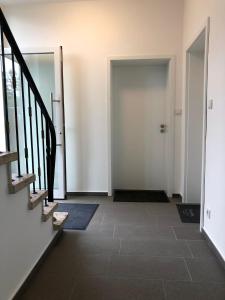 Un pasillo con una puerta y una escalera con piso. en Ferienwohnung in Kaunitz bei Wessels, en Verl 2 fotos más