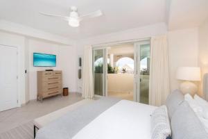 1 dormitorio blanco con 1 cama y vestidor en Beachcomber 21, en George Town