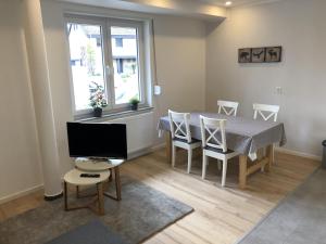 a dining room with a table and chairs and a television at Ferienwohnung in Kaunitz bei Wessels in Verl +2 photos