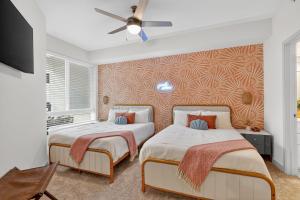 ジャクソンビルにある2 BR suite with game room & amenitiesのベッド2台と天井ファン付きの寝室 +12枚の写真