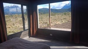 a bedroom with a large window with a view of mountains at La Casita de Joaquin in Los Cipreses