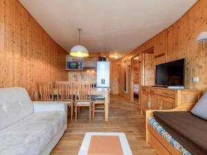 Una sala de estar y una cocina con un sofá y una mesa. en Appartement 3 pièces pour 6 pers. avec balcon et wifi, proche pistes et commerces à Avoriaz - FR-1-314-152, en Morzine