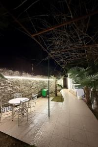 a table and chairs on a patio at night at The Journey Inn in Shkodër