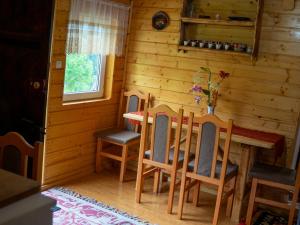 a dining room with a table and chairs in a cabin at Casa din deal-Apuseni 