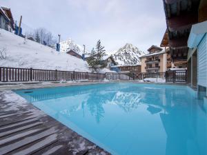 a swimming pool in the snow with snow covered mountains at Arc 1950: Apt 10 pers, 4 ch, ski pieds, wellness, wifi - FR-1-686-44 in Arc 1950