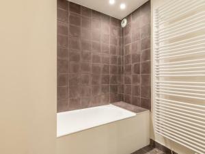 a bathroom with a tub and a shower with tiled walls at Chalet d'exception à Avoriaz, 12 personnes, 7 pièces, ambiance alpine - FR-1-314-306 in Avoriaz +9 photos