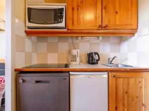 a kitchen with a microwave and a dishwasher at Studio 4 pers à Avoriaz, au calme avec balcon - FR-1-314-314 in Avoriaz