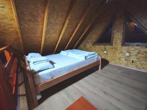 ein kleines Bett in einem Zimmer mit einer Steinmauer in der Unterkunft Brvnare Tomić 2 i 3 in Ždrelo