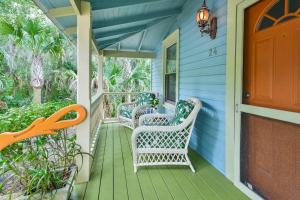 a porch with three wicker chairs on a blue house at Little Blue Cottage in St. Augustine