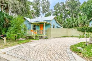 a blue house with a fence and a brick driveway at Little Blue Cottage in St. Augustine
