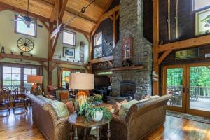 an open living room with a stone fireplace at D-Coys Nest in Banner Elk