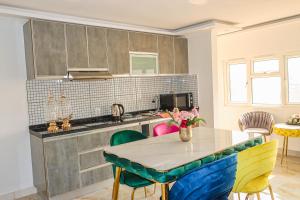 a kitchen with a table with chairs and a counter at Lá Maison Jolly in Luanda