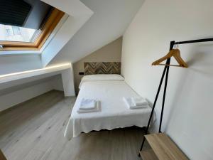 Un dormitorio pequeño con una cama y una ventana. en Cíes Premium Suitel Ponte 9 - Love your Stay, en Marín