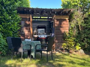 a table and chairs in a backyard with a grill at Studio Cedar Guest Cottage in Duncan
