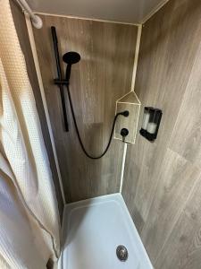 a bathroom with a shower with a sink and a toilet at הקרוואן במושב in Beʼerotayim