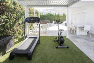 a patio with exercise equipment on the grass at Villa Elouise Heated Pool Gym Jacuzzi Sauna in Benalmádena