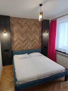 une chambre avec un lit et un rideau rouge dans l'établissement Zefir Horynia, à Lviv