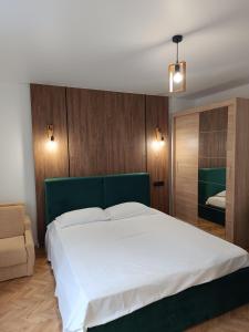 une chambre avec un grand lit blanc et une chaise dans l'établissement Zefir Horynia, à Lviv