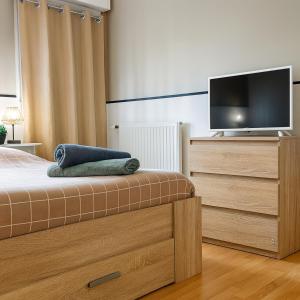 Dormitorio con cama y tocador con TV en T2 paisible avec balcon verdoyant, en Angers