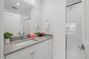 Un baño blanco con lavabo y ducha. en 301 W Meadow Mile #3, en Fraser 26 fotos más