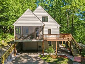 a house with a large deck with a porch at Tranquil NH Lakehouse Escape in Moultonborough