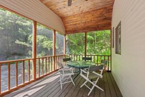 a screened in porch with a table and chairs on it at Tranquil NH Lakehouse Escape in Moultonborough