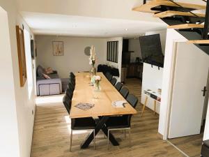 a dining room and living room with a wooden table at Le Gîte du Plessis Montanel à 25 mn du Mont Saint-Michel in Montanel