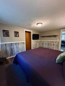 a bedroom with a bed and a tv on the wall at Fall Getaway in Auvinen Corner