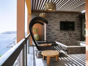 a balcony with a tub and a chair and a table at Pullman Dakar Teranga in Dakar