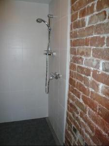 y baño con pared de ladrillo y ducha. en Aisa Beach Area Holiday Home, en Pärnu