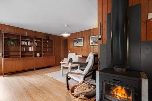 a living room with a fireplace with a couch and a chair at VAS109-Kalv-Roesarp-Sperlingsholm-203 in Kalv
