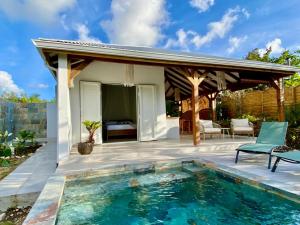a patio with a swimming pool and a pavilion at Kôsy in Grand-Bourg