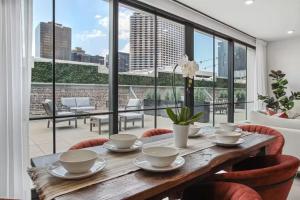 a dining room with a table and chairs and a large window at The Theodore New Orleans in New Orleans