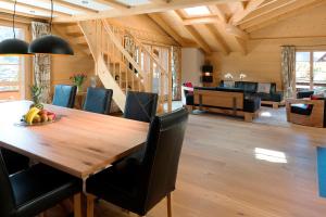 uma sala de jantar e sala de estar com uma mesa de madeira e cadeiras em Apartment Alpenblume - GRIWA RENT AG em Grindelwald