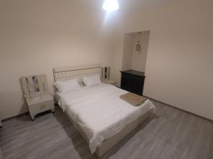 a bedroom with a white bed and a night stand at Parkside Residences in Tbilisi City